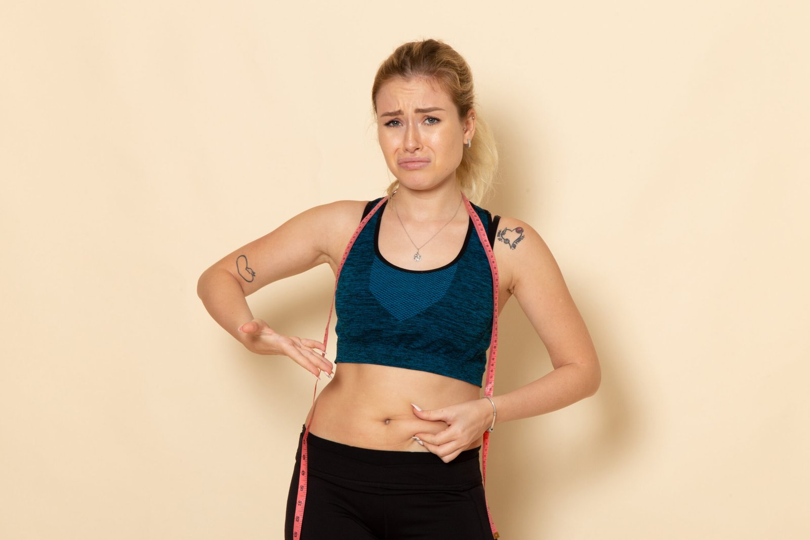 Woman in sportswear measuring her waist